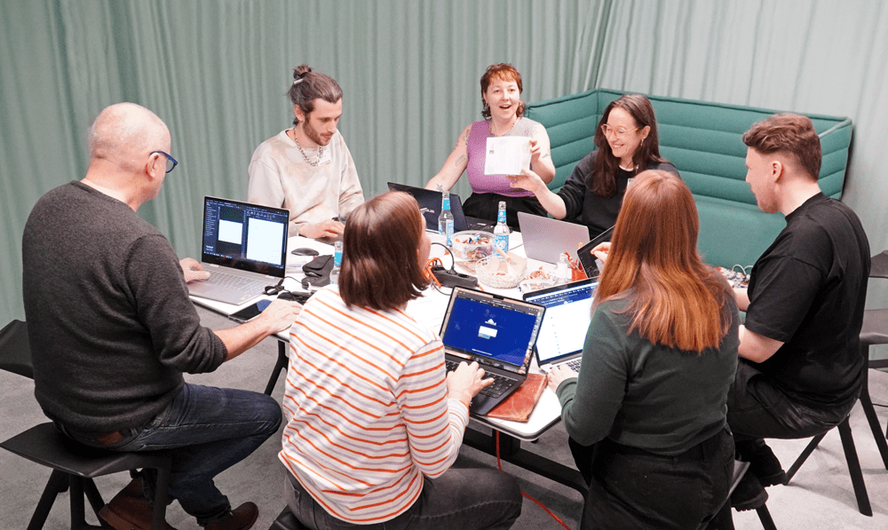 Eine Gruppe von Volunteers arbeitet an einem Tisch während der "Nachtschicht (Berlin)" von UPJ